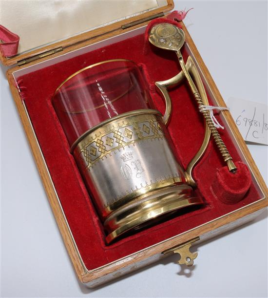 A 19th century Russian 84 zolotnik parcel gilt silver tea glass holder and similar spoon, in fitted wooden case, 3.5 oz.